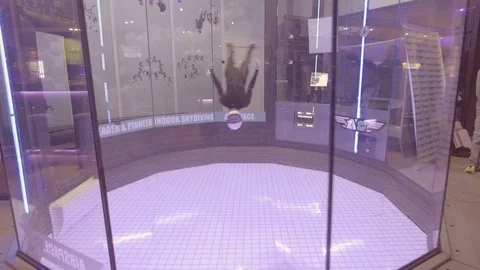A parabolic chamber indoor skydiving simulator allows people to float as if in a Vidéo 106628071