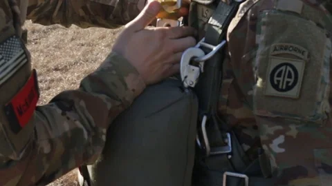Parachute being checked on paratrooper prior to jump Stock Footage 85597817