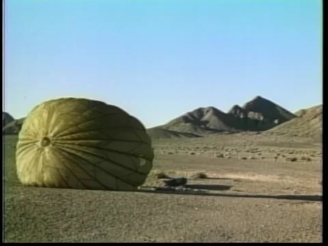 Parachute closing flat after landing in desert, 1970s 스톡 동영상 260258447