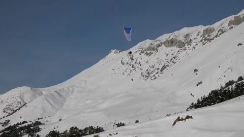 Parachute skydiver flying in clouds above mountains with snow in the ski resort. Stock Footage 157268627
