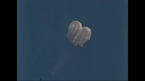 Parachutes and retrieval methods for a returning manned spacecraft are tested, Stock Footage 115349103