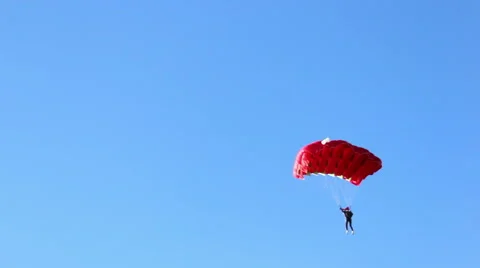 Parachutist comes down to earth, red chute Stock Footage 52141703
