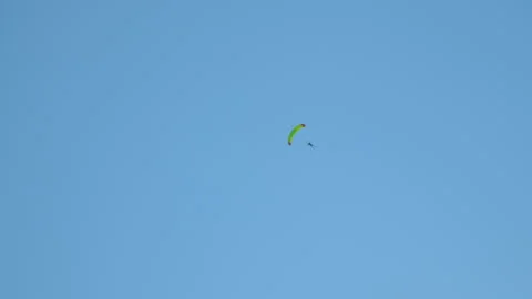 The parachutist descending to the ground makes quick movements and various Stock Footage 245349660