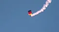 Parachutist with german flag colored parachute and smoke HD Footage
