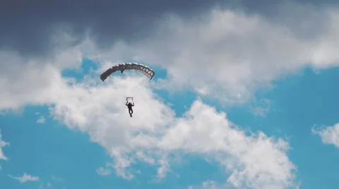 Parachutist lands on a background of clouds and blue sky Stock Footage 68354425