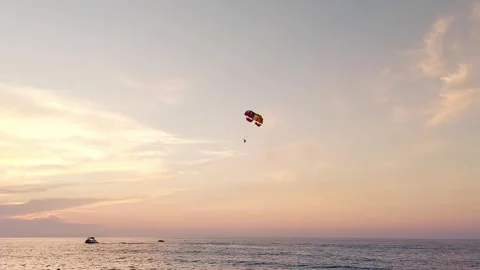 Parachutist in the sky against the backdrop of sunset and sea. Extreme Stock Footage 304110488