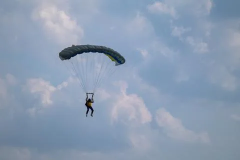 Parachutist soars through blue cloudy sky Photos