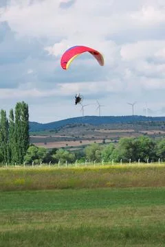 Parachutists approaching ground at cloudy sky Stock Photos