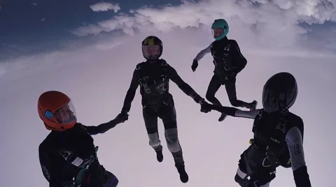 Parachutists holding hands in sky. Skydiving. Flight above green fields Video stock 64240437