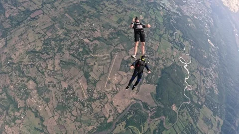 Parachutists jumping from a plan and performing maneuvers in the air Video stock 259027971