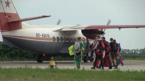 Parachutists with multi-colored parachutes go to aircraft L-410 for landing. Stock Footage 121203352
