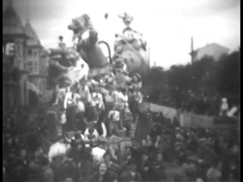 A parade of extravagant floats go through a crowded street. Stock Footage 75763993