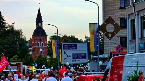 Parade heading toward St Simon church tower at Valmiera city Festival Vídeos de archivo 316576510