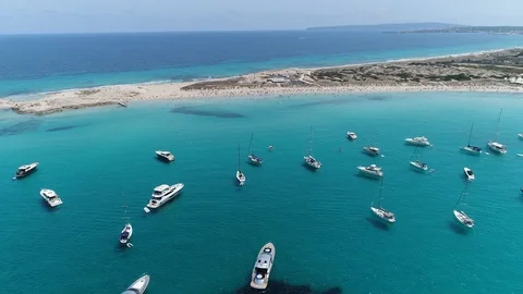 Paradise beach - tracking shot behind boats moored up in the sunshine Stock Footage