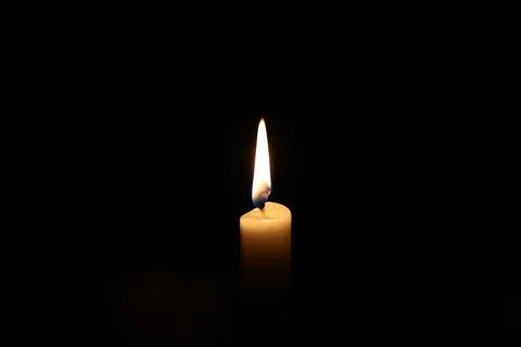 Paraffin candle in complete darkness Stock Photos