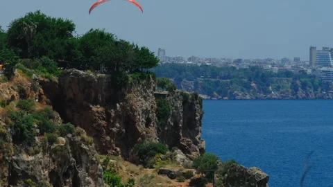 Paraglider Above Mediterranean Cliffs and Antalya Coastline Beneath Clear Blue Stock Footage 336252679