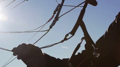 Paraglider adjusting the cables of parachute Stock Footage 76003409