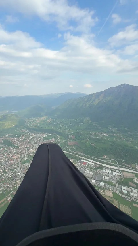 A paraglider captures wide views of a sprawling town and lush valley. The pilot 库存影片 334316590