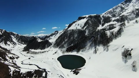 Paraglider coming down against the background of the beautiful lake and the snow Stock Footage 196803959
