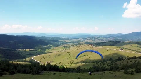 The paraglider descends from the top of the mountain using the strong wind 03 Stock Footage 171294080