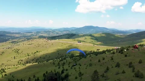 The paraglider descends from the top of the mountain using the strong wind 05 Stock Footage 171294210