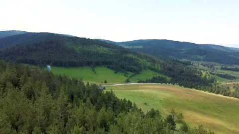 The paraglider descends from the top of the mountain using the strong wind 07 Stock Footage 171294711
