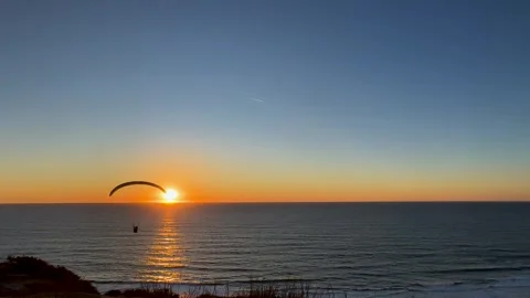 Paraglider doing tricks across a beautiful clear sunset at Torrey Pines Video stock 266229128