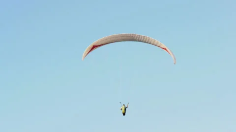 Paraglider flies against the background of a blue sky Stock Footage 157187633