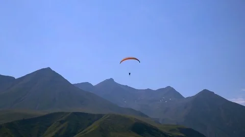 Paraglider flies against background of high mountains and clear blue sky 스톡 동영상 80904779