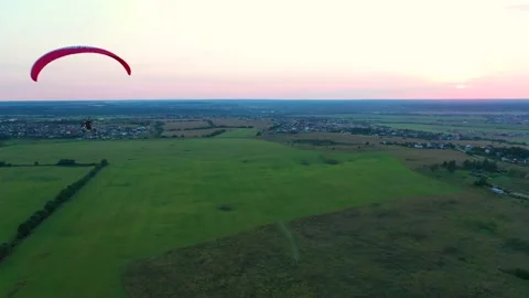 The Paraglider Flies Over The Green Fields Stock Footage 137032961