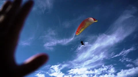 Paraglider flies in the sky over the mountains on a bright sunny day Paragli Stock Footage 170785332