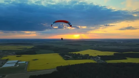 A paraglider flies at sunset against Stock Footage 196135973