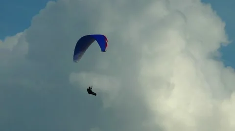 Paraglider floating in the sky by beautiful clouds. Stock Footage 68725696
