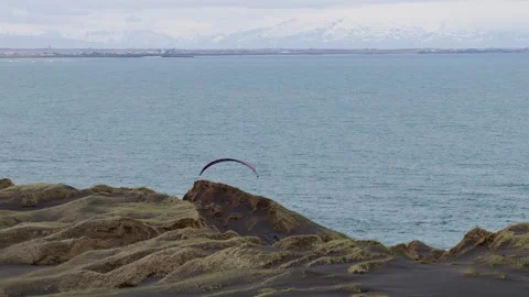 Paraglider flying above volcanic coastal cliffs and the Atlantic Ocean in Vidéo 344122851