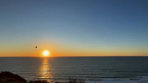 Paraglider flying back and forth across a beautiful clear sunset at Torrey Video stock 266229071