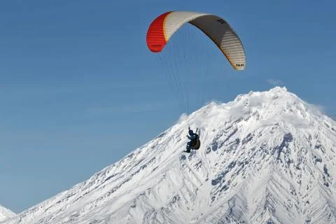 Paraglider flying on background of active volcano Stock-Fotos