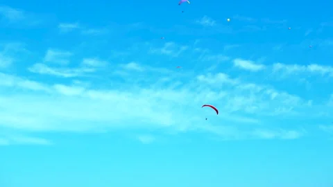 Paraglider flying in blue sky with distant colorful parachutes. Stock Footage 332774388