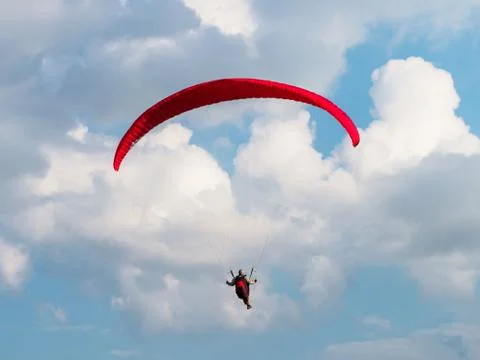 Paraglider is flying in the blue sky. Stock Photos