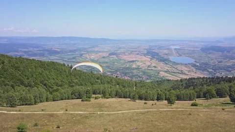 Paraglider flying close to the ground, slow flight above forest. Woman Stock Footage 261503098