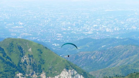 Paraglider Flying High in the Sky Over Mountain Slope Stock Footage 335218631