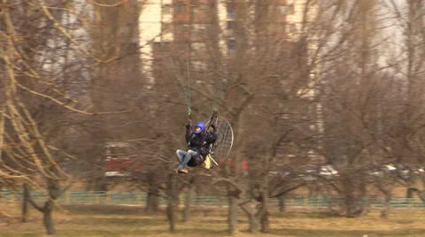 Paraglider flying low through the trees in the city Stock Footage 36540127