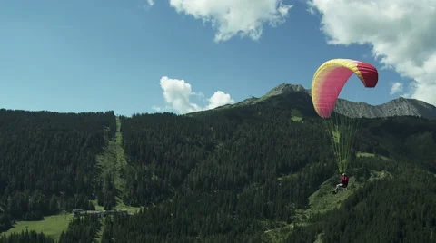 Paraglider flying next to camera in the austrian alps Stock Footage 58624822