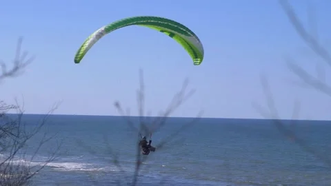 Paraglider flying over the ocean on a clear day in 4K slow motion 60fps Stock Footage 282533572