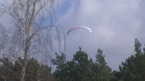 Paraglider flying over the ocean on a clear day in 4K slow motion 60fps Stock Footage 282543862