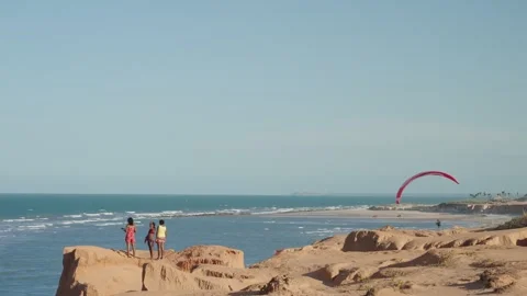 Paraglider Flying Over Red Cliffs and Ocean in Brazil Stockbeeldmateriaal 327722252