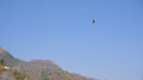 Paraglider flying over tree covered hills in the himalayas Stock Footage 88333701