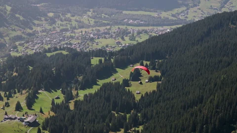 Paraglider flying through the sky over the valley at Zermatt Video stock 255416165