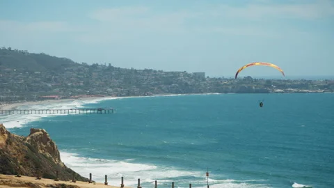 A Paraglider flys along the coast Stock Footage 201886552
