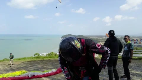 Paraglider getting ready with his pieces of equipment to take off. 4K Stock Footage 241121444