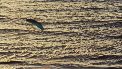 Paraglider gliding on waves during sunset Stock Footage 73904683
